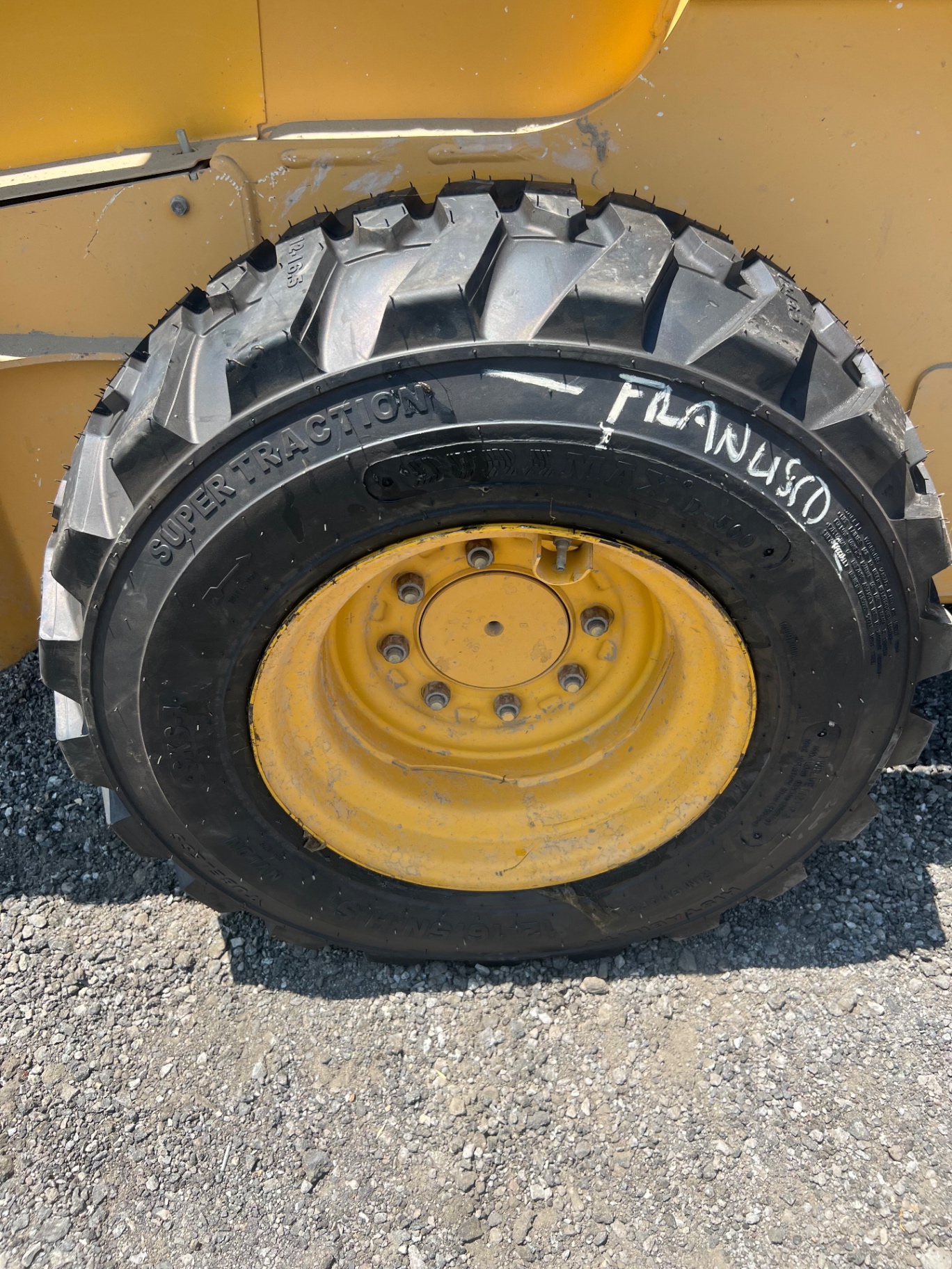 Skid steer Super Traction tire mounted on yellow wheel by F&K Tires LLC